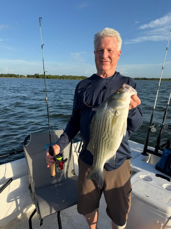 Smiling angler holding a white bass caught on a lake fishing charter