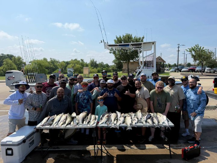 Family group smiling behind a table of fresh caught fish after a fishing charter trip